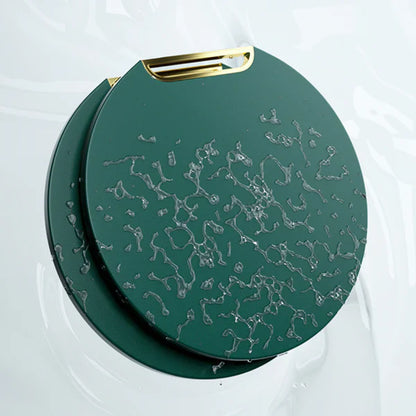 Bolsa redonda verde escura com textura abstrata cinza e alça dourada, sobre fundo branco