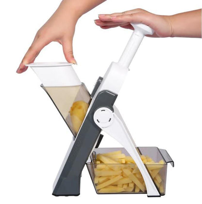 Mandoline manual branca e cinza cortando batatas em palitos com mão empurrando o alimento