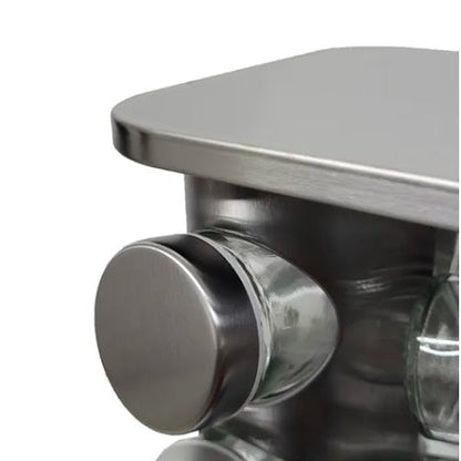 Canto inferior de uma mesa de aço inox com acabamento escovado, mostrando um botão circular metálico