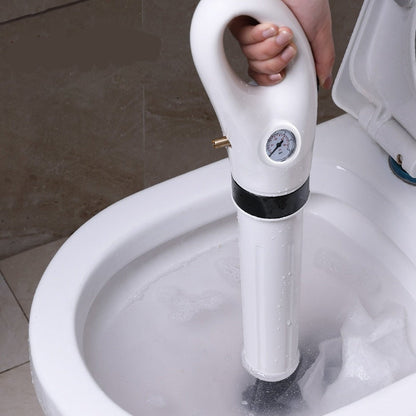 Desentupidor elétrico branco em uso dentro de vaso sanitário, mão segurando o cabo com manômetro
