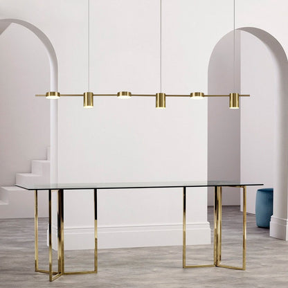 Mesa de vidro com base dourada e lustre pendente minimalista dourado em sala branca com arco