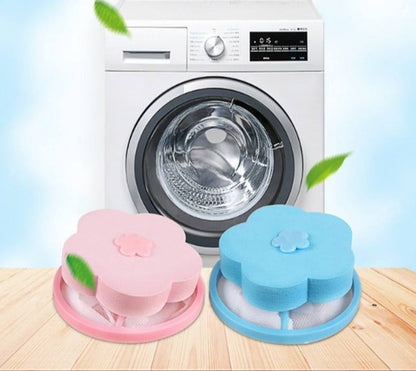Máquina de lavar roupa branca com filtros de fiapos em forma de flor rosa e azul sobre superfície de madeira