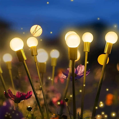 Luzes decorativas em forma de pequenas lâmpadas brilhando em um jardim com flores à noite