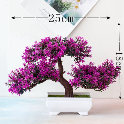 Bonsai artificial com flores roxas em vaso branco, medindo 25 cm de largura por 18 cm de altura
