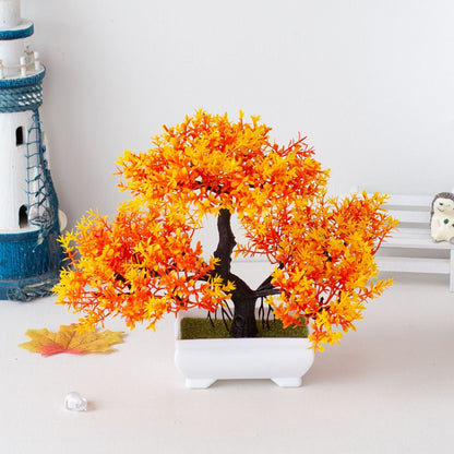 Bonsai artificial com folhas laranja e amarelas em vaso branco, decoração minimalista