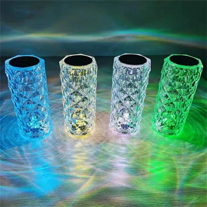 Quatro copos de vidro transparentes iluminados com luzes coloridas azul, amarelo e verde refletindo padrões geométricos