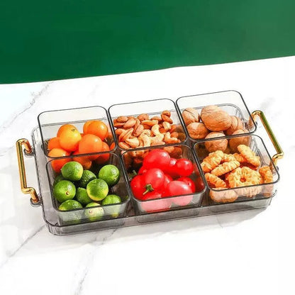 Bandeja multifuncional com potes organizadores transparentes contendo frutas, castanhas e biscoitos sobre mesa branca