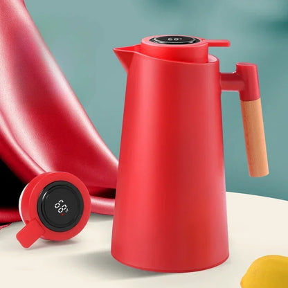 Garrafa térmica vermelha com termômetro digital no topo e alça de madeira sobre mesa clara
