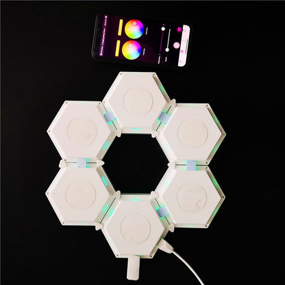 Luminária de parede hexagonal tipo favo branca com controle via aplicativo em smartphone sobre fundo preto