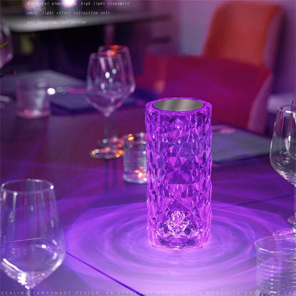 Luminária decorativa roxa em vidro facetado iluminando mesa com taças de vinho em ambiente sofisticado