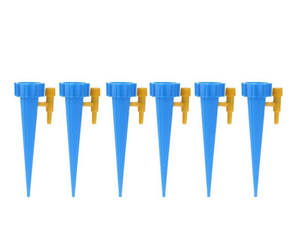 Seis gotejadores azuis com válvulas amarelas para irrigação automatizada no jardim