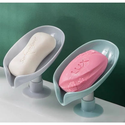 Sabonetes Solidos branco e rosa em suportes plásticos modernos sobre pia com fundo verde