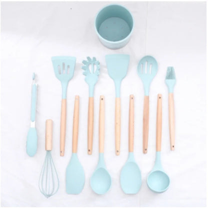 Conjunto de utensílios de cozinha em silicone azul claro com cabos de madeira, sobre fundo branco