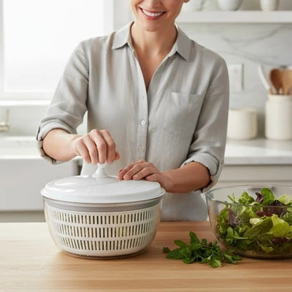Mulher usando centrifuga de salada branca na cozinha moderna com tigela de folhas verdes