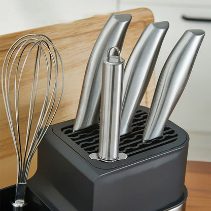 Suporte de talheres em aço inox com facas e fouet organizados sobre bancada de cozinha