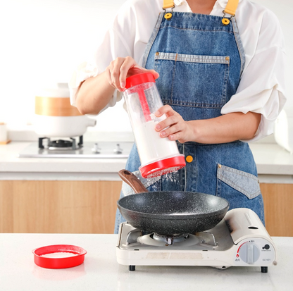 Pessoa usando avental jeans adiciona farinha em frigideira sobre fogão portátil em cozinha moderna