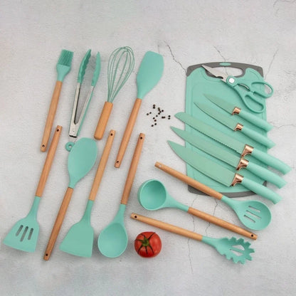 Utensílios de cozinha verde-água com cabos de madeira e conjunto de facas sobre tábua cinza